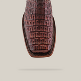 Close-up of a single Exotic Caiman Hornback boot in rich brown, showcasing luxurious hornback details with a Rodeo toe against a neutral background.