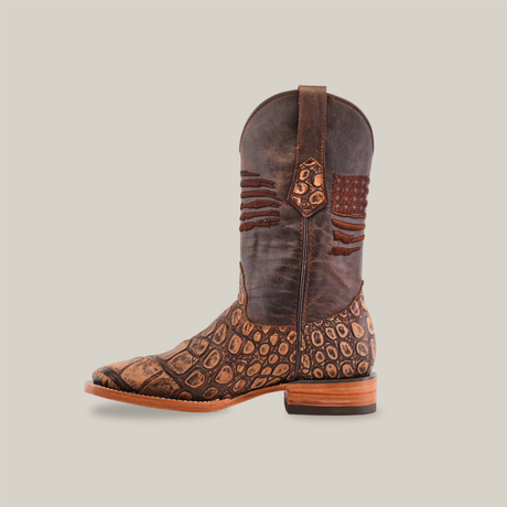 A handcrafted cowboy boot named American Alligator Print Rustic Brown - Square Toe features dark brown and tan leather with an alligator print on the foot and upper shaft, a stacked heel, and decorative stitching, all set against a plain white background.