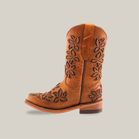 The Cosala Honey - Snip Toe cowboy boot features a side view in brown genuine leather with floral embroidery, a medium heel, and a rounded toe. Leaf and flower patterns adorn the shaft and foot against a crisp white background, offering a classic western look.