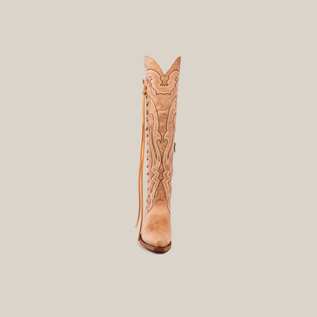 The Tania Orix womens cowboy boot in tan, shown from the front, showcases intricate stitching and a decorative tassel on the side. It features a snip toe and a tall shaft, set against a white background.