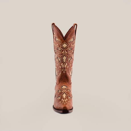 The Nataly Brown - Mid Shaft - Snip Toe boot, crafted by skilled artisans, boasts intricate white embroidery on quality leather. Its pointed toe and tall, decorative shaft are elegantly highlighted against a plain white background.