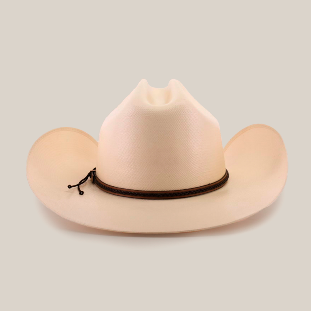 The 1000X Country Straw Hat is a beige cowboy hat, made from high-quality materials, featuring a wide brim and a decorative brown band. The prominent crease on its front adds to its classic charm against the white background.