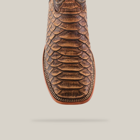 Close-up of a Jumbo Python Print Cappuccino cowboy boot with a square toe, showcased against a white background. Meticulously handcrafted by artisans, it features intricate edge stitching.