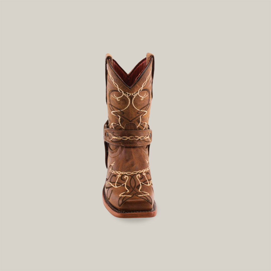 The Graffiti Yellow - Rodeo Toe is a brown cowboy boot made from genuine leather, featuring intricate white stitching and decorative patterns. Ideal for young cowgirls, it offers a stylish pointed toe and mid-height heel for comfort, set against a plain white background.