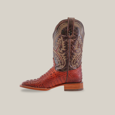 The Caiman Hornback Print Cogñac - Square Toe boot boasts a handcrafted cowhide shaft with intricate stitching, a crocodile-like print foot, a wooden heel, and a pull-on tab—blending rugged charm with elegance.