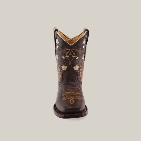 The Dariela Chocolate - Square Toe is a premium leather cowboy boot in dark brown, featuring intricate floral embroidery and stitching. This elegant piece is displayed front-facing against a plain white backdrop.