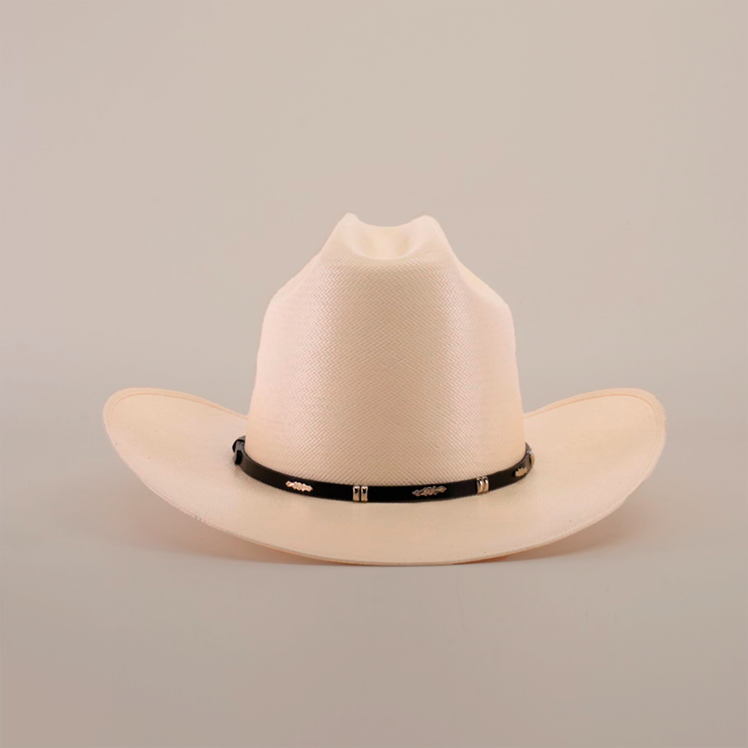 The 500X Dos Carnales Straw Hat is cream-colored with a wide brim and slightly pinched crown, highlighting its quality and durability. It has a black band adorned with decorative gold elements on a plain white background.