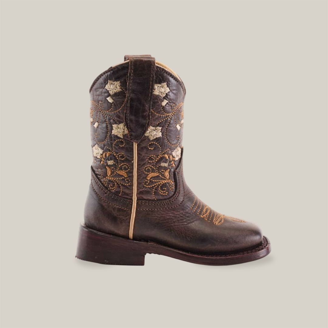 A single Dariela Chocolate - Square Toe brown cowboy boot is crafted from premium leather with intricate golden floral embroidery and star designs. It stands on a plain white background, featuring a thick heel, pull tab, and chic chocolate square toe for added style.