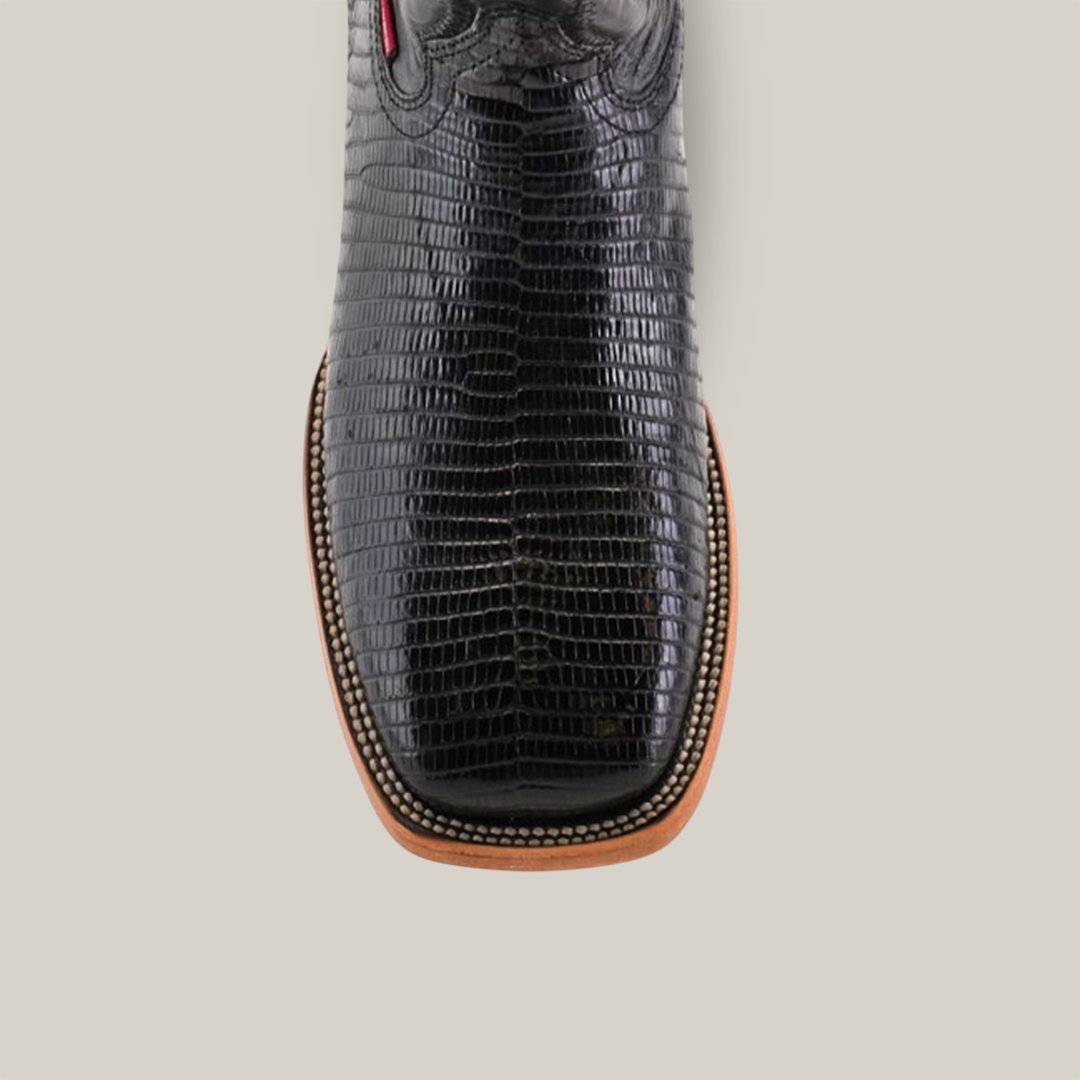 Close-up of the Exotic Lizard - Black cowboy boot featuring a lizard-textured design, square toe, brown sole, and intricate edge stitching. The boot is set against a plain white background.