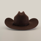 The 6X Country Brown cowboy hat, made from premium sheep wool, features a wide brim and slightly indented crown. A black band accents its base, exuding Western classic charm. The hat is elegantly set against a plain white background.