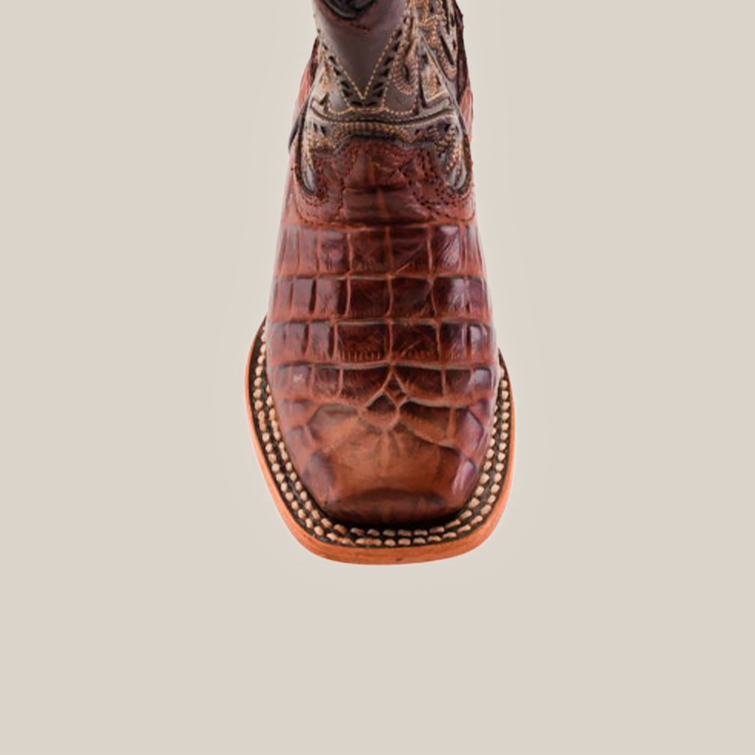 Close-up of a handcrafted Caiman Belly Print Chocolate Square Toe boot with intricate stitching and decorative patterns on premium leather, complemented by a light brown sole, exuding timeless elegance.