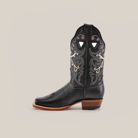 The Western Stitch Black Lustre boot, featuring a narrow square toe, black premium leather, decorative white stitching, and a brown heel, embodies traditional craftsmanship. Viewed from the side on a pristine white background, it captures the essence of Western spirit.