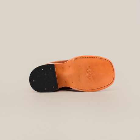 The image displays the sole of the Prime Suede Honey Square Toe shoe on a white background. This genuine leather footwear highlights its craftsmanship with black rubber patches at the heel and toe, and visible stitching along the edges.