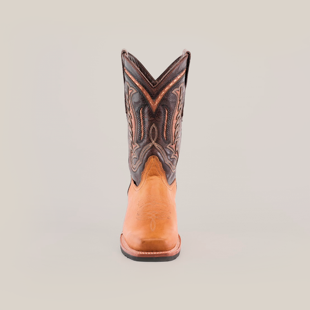 The Cater Honey features a single cowboy boot crafted from premium cowhide leather, boasting a brown lower section and a dark upper with intricate stitching. Its Western patterns offer a textured, colorful contrast atop the slip-resistant sole.