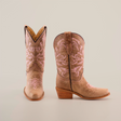 A pair of Bellere Fawn - Snip Toe boots in brown with pink embroidery and mid-height wooden heels crafted from premium cowhide leather. The left boot faces forward, and the right angles to the side, both set against a plain white background.