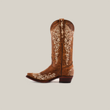 The Albine Crystals Camel boot features luxury craftsmanship with white intricate embroidery on a brown surface, crafted from premium leather. It has a low heel, a snip toe, and is shown against a plain white background.