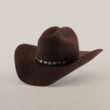 The 6X Country Brown is a dark brown felt cowboy hat crafted from premium sheep wool, featuring a wide brim and curved crown. It has a decorative black band with metallic conchos, embodying Western charm, set against a plain light background