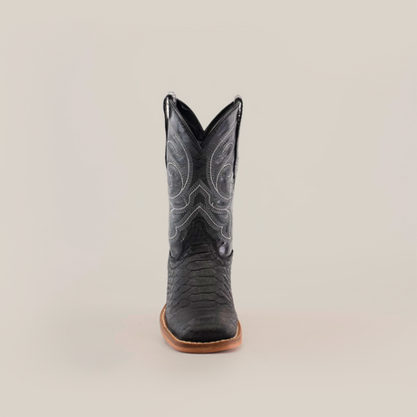 The Python Print Matte Black Square Toe is a black cowboy boot with decorative stitching on the shaft, crafted from cowhide leather. It features a textured look and a brown sole, centered on a plain white background.