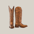 The Eden Copper Tall Shaft boots, with a narrow square toe, showcase intricate brown leather embroidery and a side zipper. One boot stands upright while the other is angled side-on, highlighting their luxury craftsmanship and block heel design.