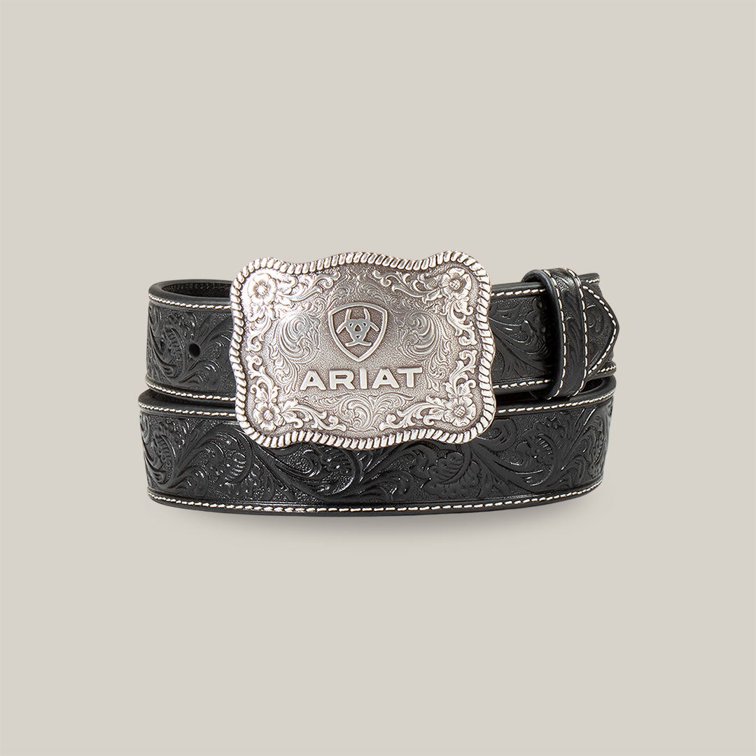 The Mens Ariat Black Embossed Plate Buckle Belt - A1020401 blends Western heritage with rugged elegance, featuring a black leather design with an embossed floral pattern and a large decorative silver buckle engraved with the ARIAT brand and shield logo.