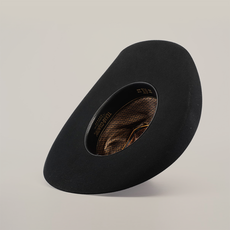 Against a light background, the 6X Brazil Black hat features a wide brim tilted at an angle. Made from premium Brazil felt, it has an inner lining with intricate brown and gold patterns reflecting Western heritage, exuding a modern and artistic design.