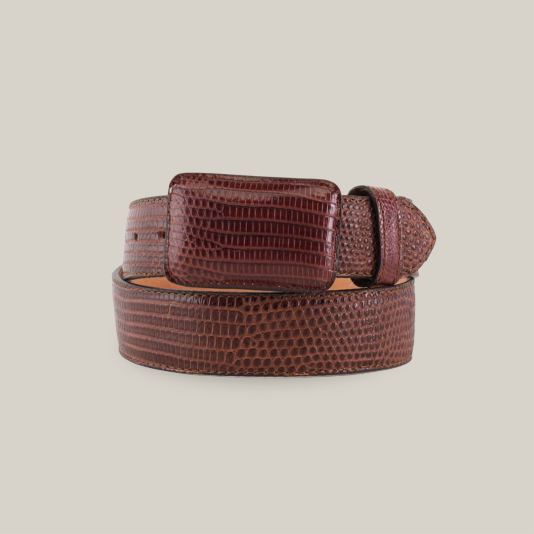 The Exotic Full Quilt Lizard - Brown Belt, coiled with a rectangular buckle, showcases sophistication on a plain white background. Its brown, textured leather elevates its appeal as a luxury accessory.