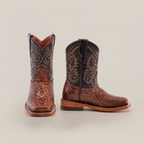 The Handtooled Leave Brown Square Toe cowboy boots display Western style, featuring intricate floral and geometric patterns on premium cowhide leather. One boot faces forward, the other side-on, showcasing exquisite stitching against a plain white background.