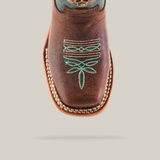 The Grecas Tabaco - Square Toe boot, crafted with traditional methods, features intricate turquoise embroidery with floral and geometric patterns. This brown western boot is made from premium leather and showcases a square toe with visible edge stitching.