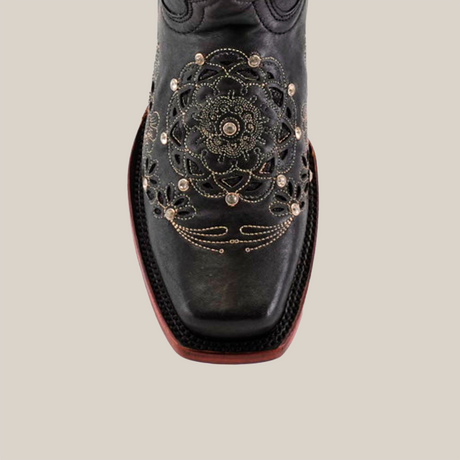 The Mayan Flower Crystals Black features metallic embroidered floral and geometric patterns on luxurious black leather. This handcrafted boot showcases a narrow square toe and a red-brown sole, set against a neutral background.