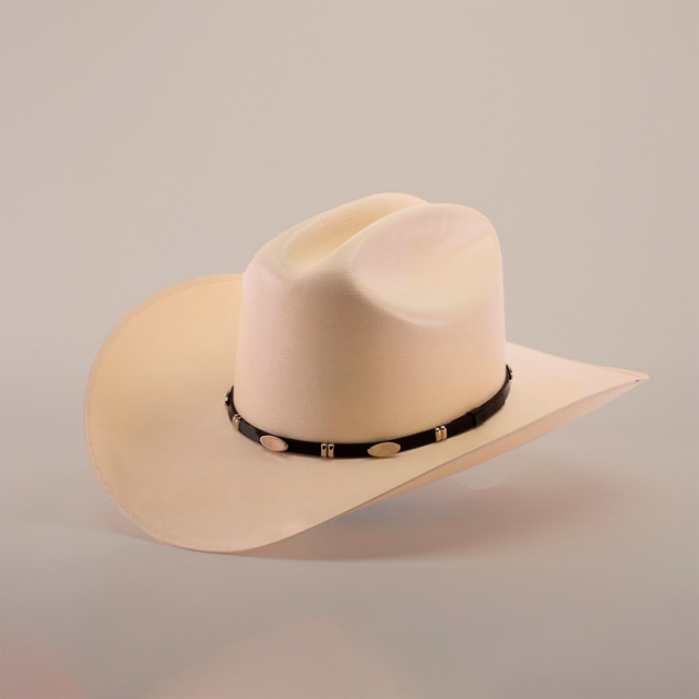 The 5000x Sinaloa Straw Hat, featuring a wide brim and black band adorned with silver oval decorations, exudes elegance and fine craftsmanship as it sits against a plain light background.