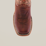 The Cheyenne Shedron Square Toe is a genuine cowhide leather cowboy boot featuring intricate western stitching and a square toe adorned with light-colored decorative accents, all set against a plain white background.