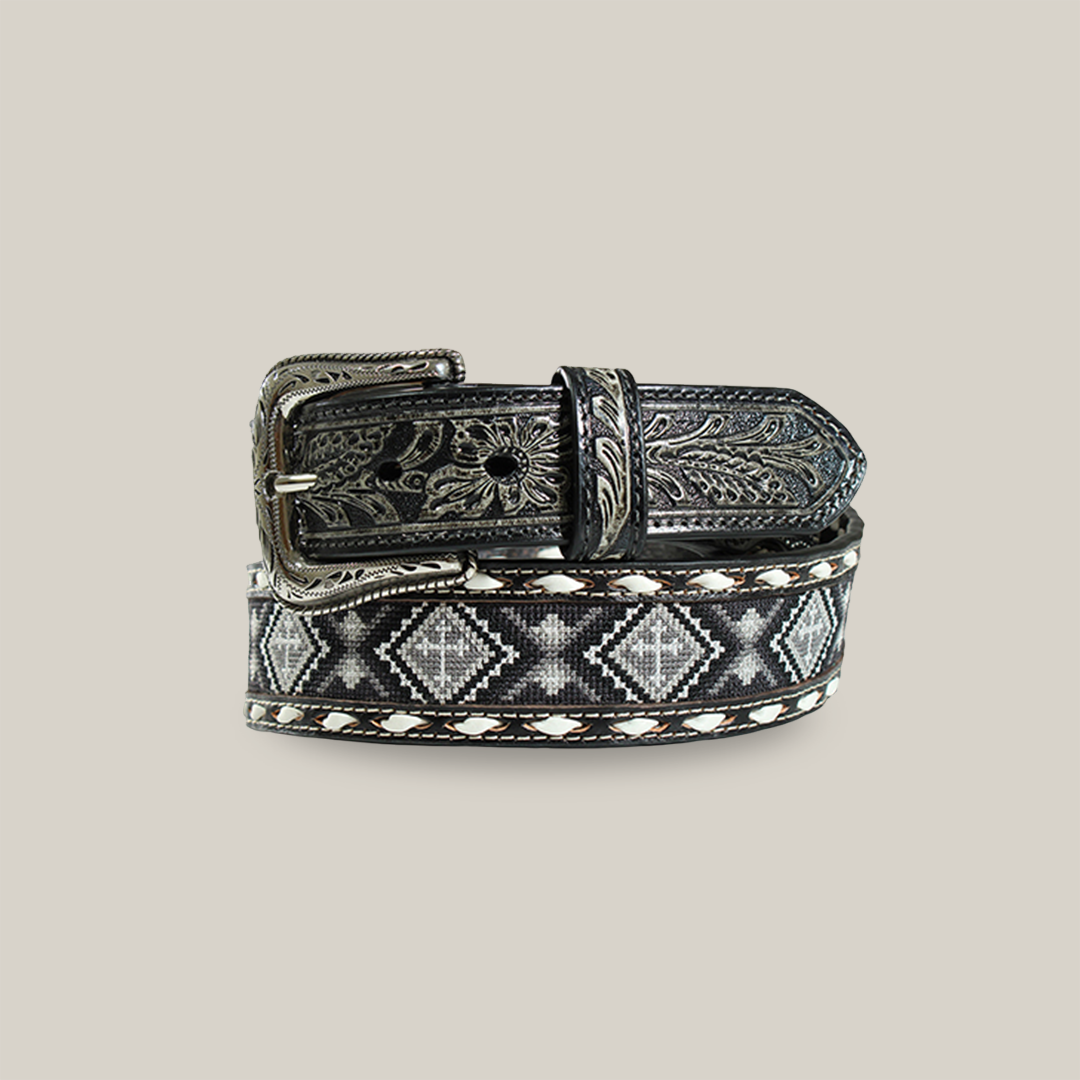 The Nocona Western Mens Belt in black leather features a buckle and tip with intricate floral engravings. It boasts a Western elegance with a stylish beaded cross and geometric diamond pattern in white and gray, bordered by sophisticated stitched detailing.