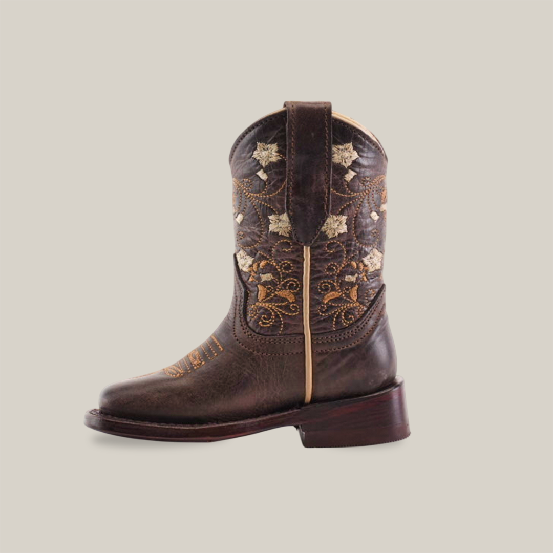 A Dariela Chocolate - Square Toe cowboy boot made from premium leather, featuring intricate golden embroidery and floral designs on the upper part, is displayed against a plain white background.