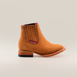 The Prime Suede Honey Square Toe is a tan leather cowboy boot featuring a square toe, decorative stitching, a branded label, and an easy slip-on side elastic panel. Its genuine leather provides a classic, rugged design set against a plain white background.