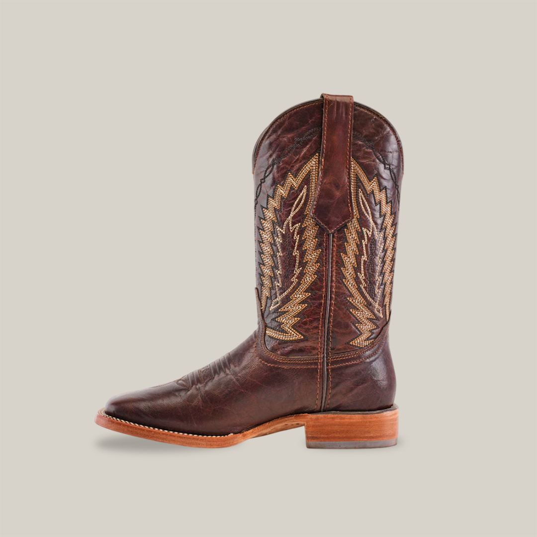 A single Dessert Camel - Square Toe boot, made from premium brown cowhide and adorned with intricate stitching and decorative patterns on the shaft, rests elegantly against a light background. The boot features a timeless design with its wooden heel.