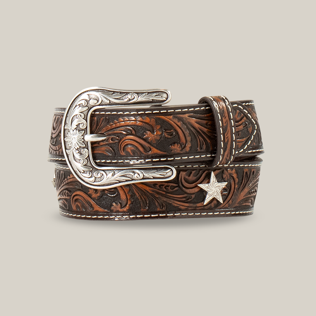 The Ariat Western Belt Leather Embossed Star Conchos Brown - A1308502 exemplifies authentic ranch style with its rolled brown leather and intricate floral engravings. It features a silver buckle with patterns, white edge stitching, and a silver star accent, making it a standout leather accessory.