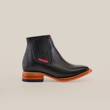 The Napa Black Square Toe ankle boot boasts luxury craftsmanship with a genuine leather finish, a square toe, and wooden sole. It features elastic ribbed sides, a red inner lining, Texana Country stitched tag, and a dark-layered heel for added elegance