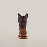 The Caiman Hornback Print Chocolate Square Toe cowboy boot is set against a white background, highlighting its exquisite leather craftsmanship with intricate stitching on the dark upper and a brown textured lower section, complete with a wooden sole, epitomizing authentic Western style.