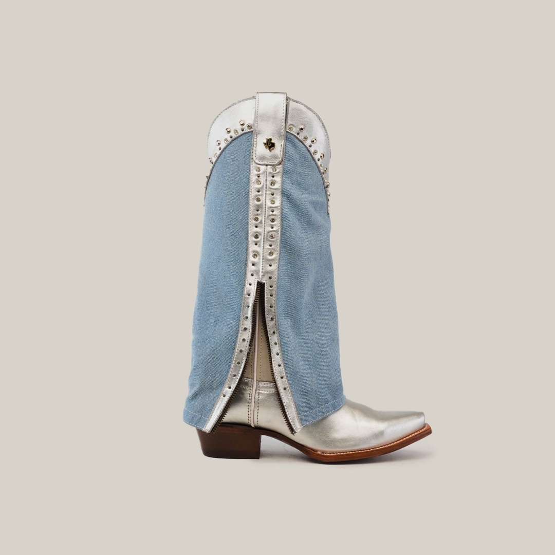 Introducing the Bella Denim Silver tall shaft boots: a stunning pair with silver cowboy charm, snip toe design, wood heel, and studded accents. The denim overlay splits to reveal a studded silver layer with button closure and tasseled flair.