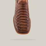 A close-up highlights the intricate stitching and unique square toe design of the Jumbo Python Print Rustic Brown - Square Toe, with a textured, scale-like pattern that stands out against a plain, light background.