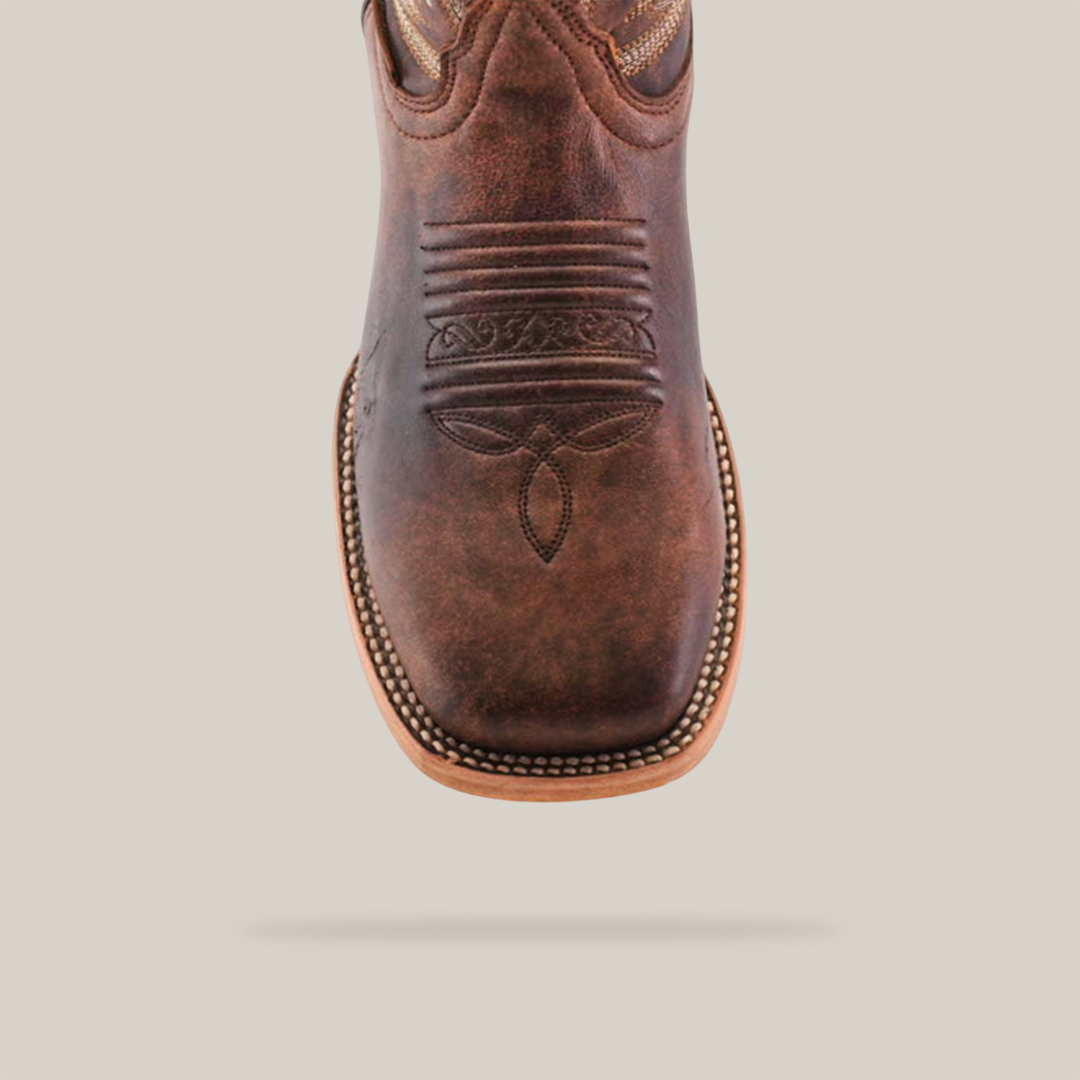 Close-up of the Bombay Camel - Square Toe cowboy boot made from premium cowhide leather, showcasing intricate stitching on the toe area and a light brown welt with visible edge stitching, all set against a plain white background.