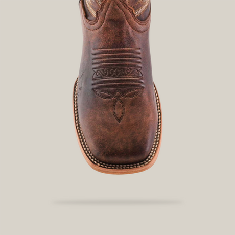 Close-up of the Bombay Camel - Square Toe cowboy boot made from premium cowhide leather, showcasing intricate stitching on the toe area and a light brown welt with visible edge stitching, all set against a plain white background.