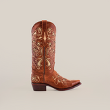 The Nataly Brown - Mid Shaft - Snip Toe boot is artisan-crafted from premium leather, showcasing intricate light-colored swirls and floral embroidery. Positioned sideways on a plain white background, it features a pointed toe and stacked heel.