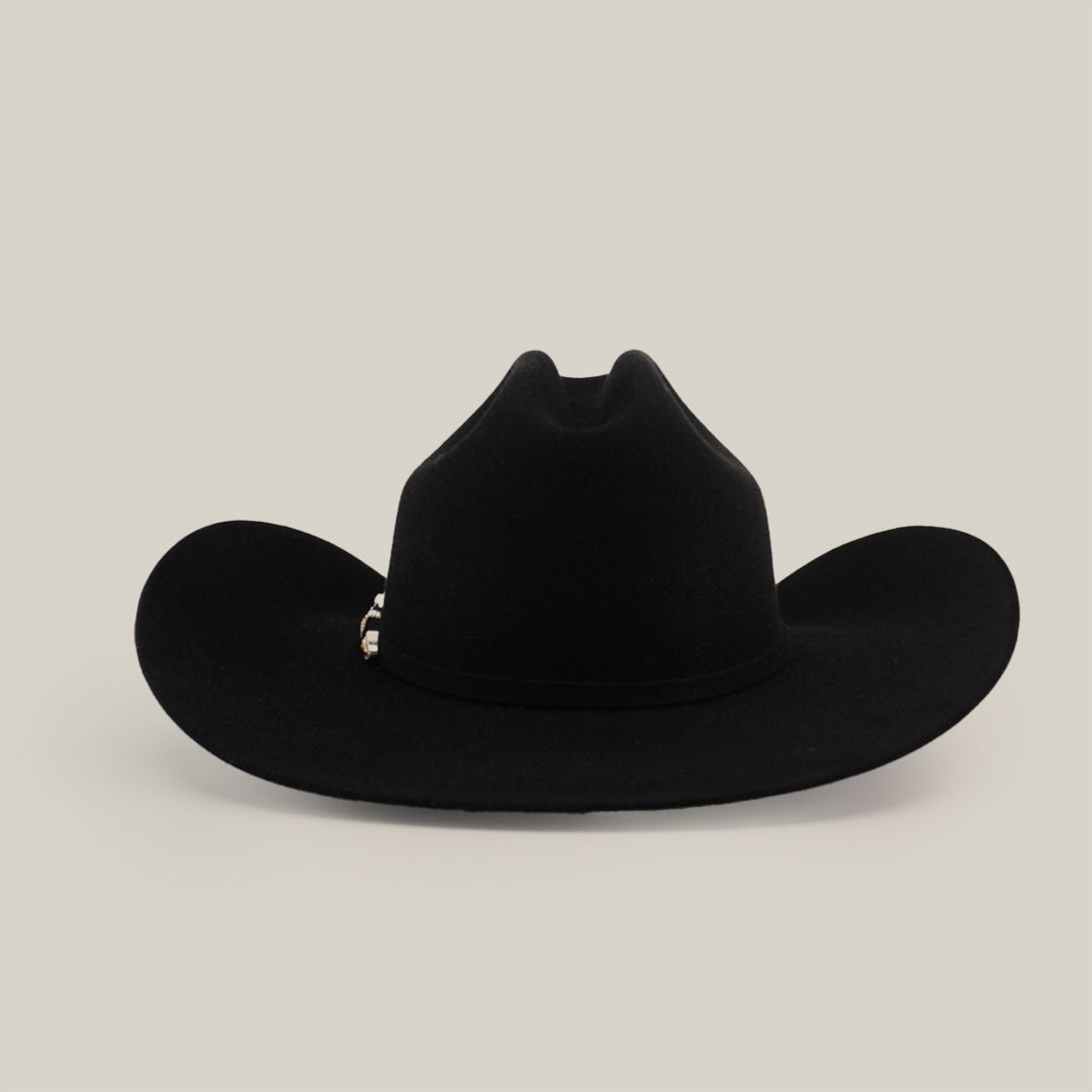 The 100X Tony Lama Black cowboy hat, made from premium beaver fur, showcases a wide brim and tall creased crown against a plain white background. A decorative silver band at the base embodies genuine Western elegance.