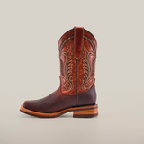 An Azkar Moka Slip Resistant Sole Rodeo Toe boot in brown leather, showcasing intricate stitching, is set against a plain white background. With a rounded toe and wooden heel, this stylish and functional boot is perfect for any occasion needing slip-resistant soles.