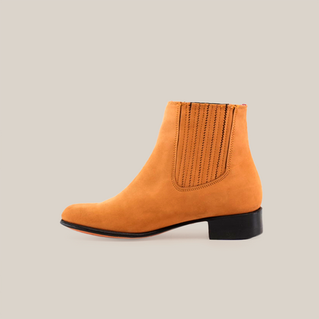 The Prime Suede Honey Round Toe ankle boot features a smooth tan finish with elastic side panels and a low black heel. Displayed in side profile against a white background, it highlights its elegant design.